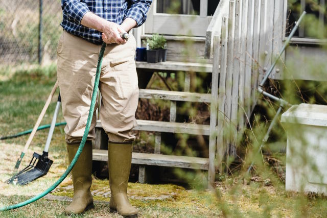 man using a garden hose